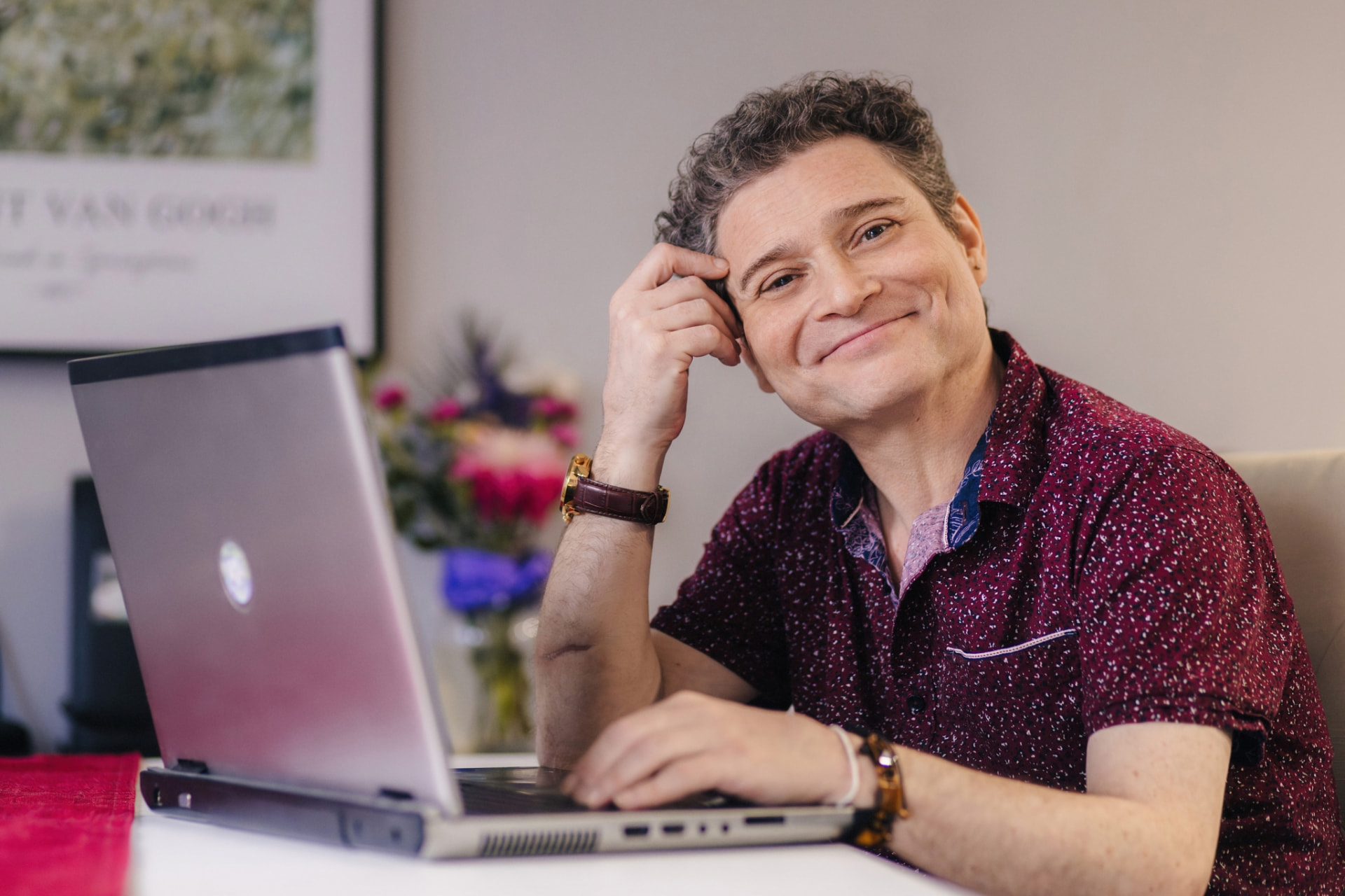 Dr. Natan Verkhovsky smiling beside his laptop